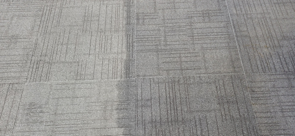 Close-up of commercial carpet tiles showing before and after cleaning by Leiter's Carpet Cleaning in Fort Wayne, IN.