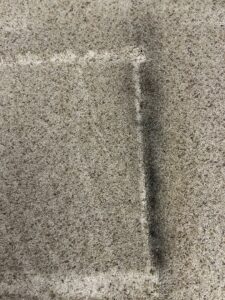 Close-up of carpet showing a clean strip next to a dirty area, demonstrating effective carpet cleaning by Greensboro Carpet Cleaning - DeepClean in Greensboro, NC