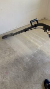 A carpet cleaning wand demonstrating the before and after effect on a light-colored carpet by Specialty Carpet Care in Surprise, AZ