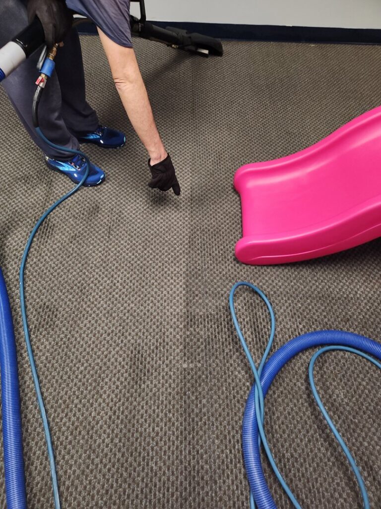 A professional demonstrating the effectiveness of carpet cleaning by Andy's Cleaning Company LLC in Topeka, KS.