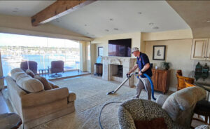A technician from First Clean SC cleaning carpet in a residential dining area in North Charleston, SC.