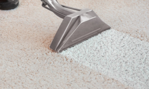 Carpet cleaning equipment in action, showing a clean path on a light carpet by Healthy Home Carpet Care in Houston, TX.