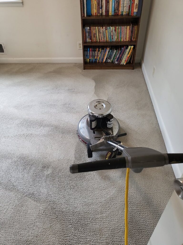 Carpet cleaning equipment actively cleaning a light-colored carpet in a living room by Greenco2 in Grand Rapids, MI.