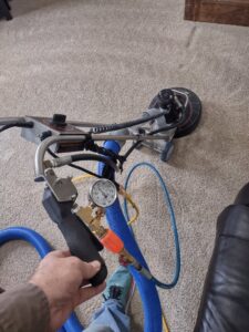 A professional using carpet cleaning equipment on a residential carpet by Customer First Carpet Cleaning in Appleton, WI
