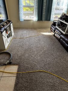 Carpet cleaning equipment and hoses set up in a living room for a job by Chem-Dry of Wichita, KS.