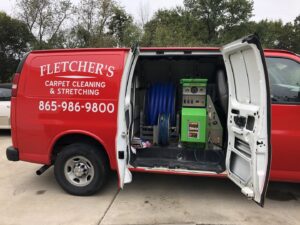 A Fletcher's Carpet Cleaning & Stretching van with its side door open, revealing professional carpet cleaning equipment in Knoxville, TN.