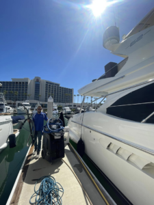 A Service Kings Home Services technician with carpet cleaning equipment ready to service a yacht in San Diego, CA.