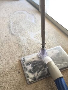 A carpet cleaning extraction tool removing dirty water from a carpet by Spectrum Cleaning & Restoration in Medford, OR
