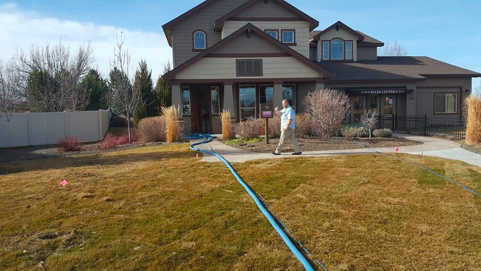 A blue carpet cleaning hose extending from a residential property during a job by Carpet Clean Team in Meridian, ID.