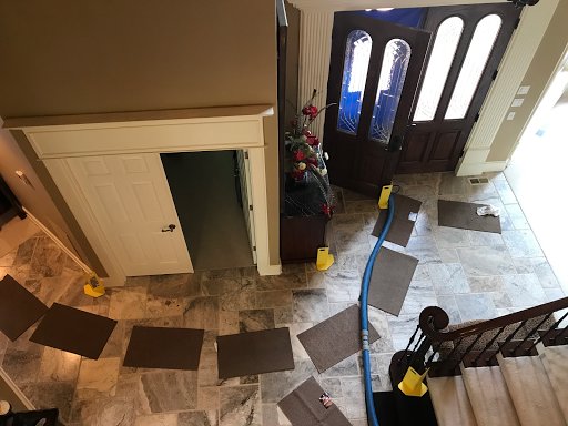 A carpet cleaning hose protected by mats in an entryway, indicating a professional cleaning job by North County Carpet Cleaning in Vancouver, WA