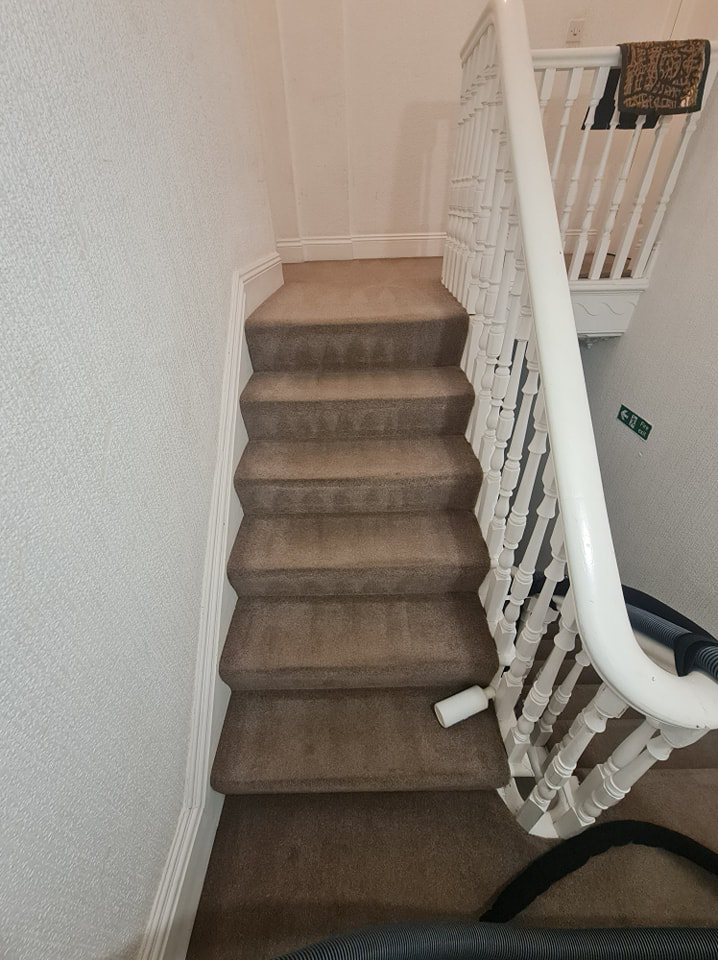 A carpet cleaning hose on a carpeted staircase during a job by Plymouth Carpet Cleaners in Hooe, UK.