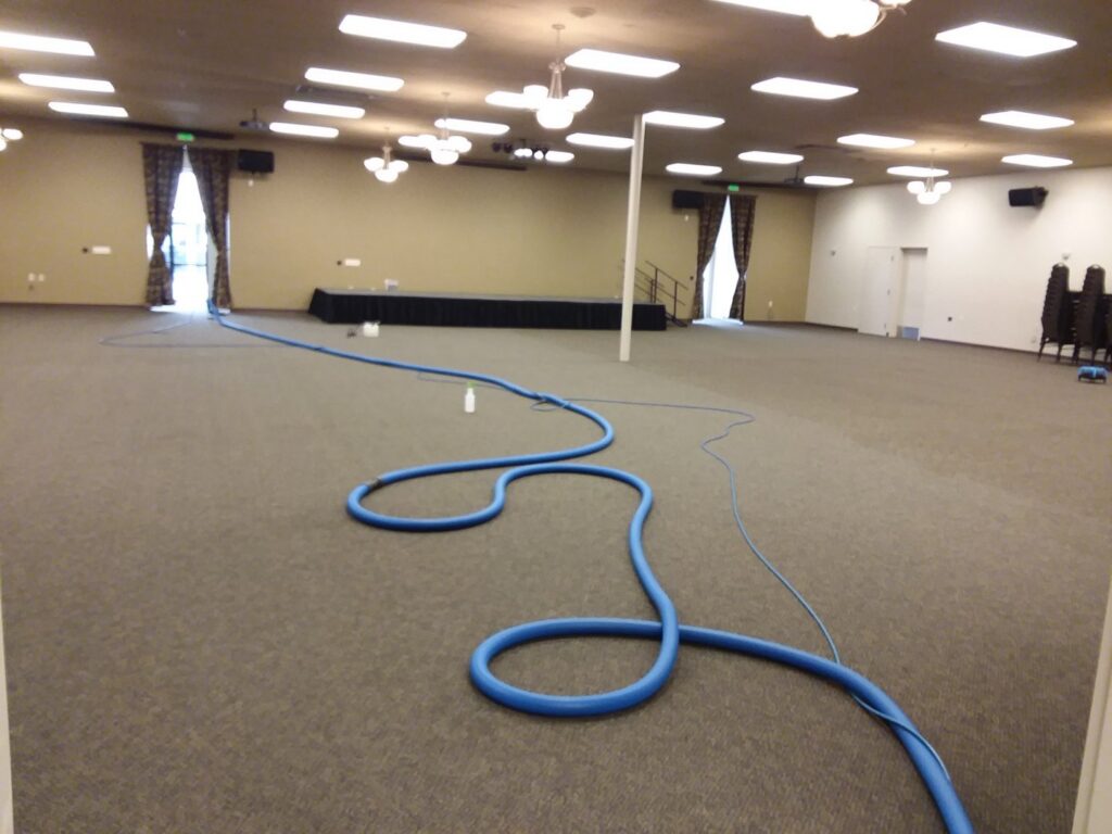 Carpet cleaning hoses laid out in a commercial room, job in progress by JR Professional Carpet Cleaning Business LLC in Spokane, WA.