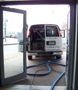 Hoses from a service van entering a building for carpet cleaning or water extraction by Enviroclean Floor Care & Restoration in South Portland, ME.