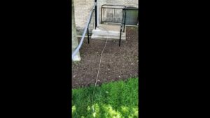 Carpet cleaning hoses extending from a truck-mounted unit to a job site entrance for KODA Carpet Cleaning in Holland, MI.
