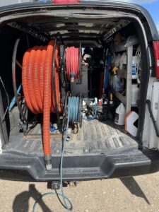 Coiled hoses and cleaning supplies neatly stored in the back of a Carpet Master service van in Aberdeen, SD.