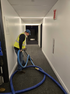 A professional cleaning carpet in a commercial hallway by Aardvark Dean Of Clean in Nashua, NH.