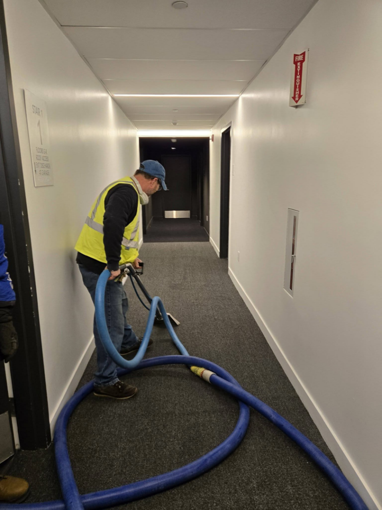 A professional cleaning carpet in a commercial hallway by Aardvark Dean Of Clean in Nashua, NH.
