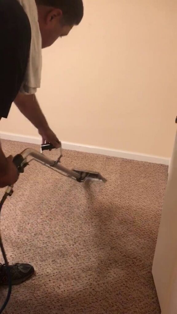A professional from Alex's Janitorial and Carpet Cleaning performing carpet cleaning with a wand in Bakersfield, CA