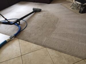 Professional carpet cleaning in progress, showing a clean path on a beige carpet by All American Carpet & Tile in San Diego, CA