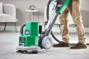 A professional from Chem-Dry Nona operating a carpet cleaning machine on a light-colored carpet in Orlando, FL.