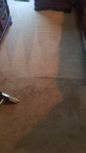 Carpet cleaning in progress with a cleaning wand on a dirty carpet by Drew's Cleaning and Restoration in Jamestown, NC.