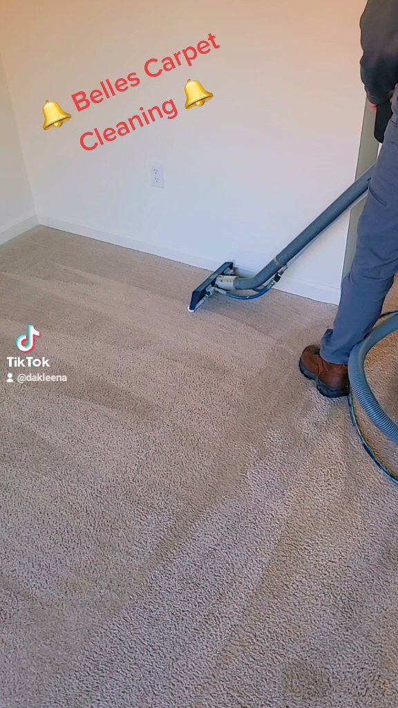 A professional using a carpet cleaning wand to clean a carpeted floor, showing the job in progress by Belles Carpet Cleaning & Janitorial Inc. in Harrisburg, PA.