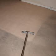 A professional carpet cleaning wand in use, showing the clean and dirty sections of a carpet by Carpet Clean Oahu in Honolulu, HI.