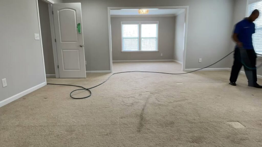 A professional performing carpet cleaning in a residential room for Winston Salem Carpet Cleaning by Hernandez in Greensboro, NC.