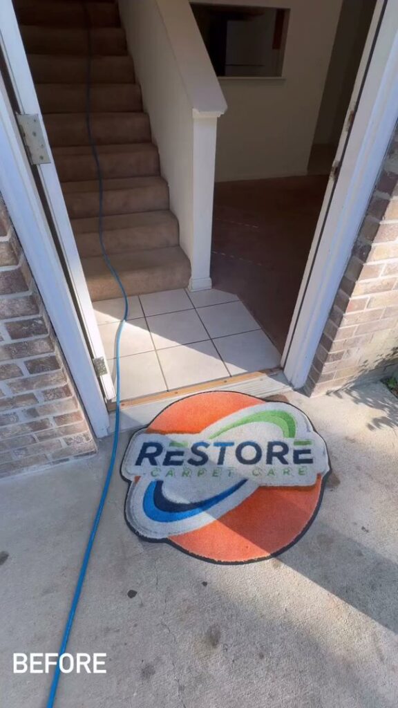 Carpet cleaning job setup at an entrance with a hose and branded mat by Restore Carpet Care and Tile in Tallahassee, FL