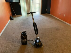 A carpet cleaning machine and sprayer ready for use in a room by Iclean Indy, a carpet contractor in Indianapolis, IN.
