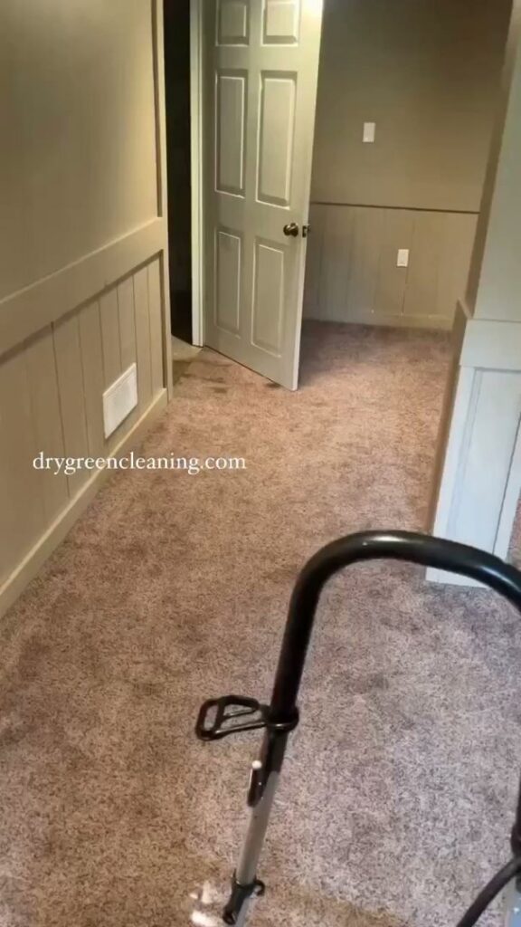 A carpet cleaning machine working on a brown hallway carpet, showing clean lines, by Dry Green Cleaning in Detroit, MI.