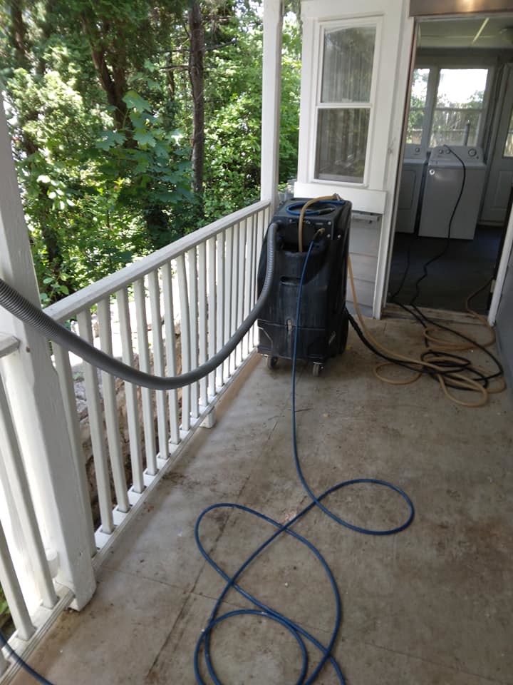 Professional carpet cleaning machine and hoses set up on a porch by Magic Carpet Cleaning in Pittsburgh, PA.