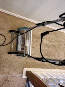 A professional carpet cleaning machine in operation on a carpeted floor by Genie Clean Services LLC in Dallas, TX.