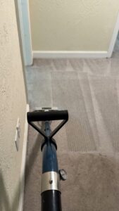 A carpet cleaning machine in action, showing clean and dirty sections, by PRIME CLEAN VA in Virginia Beach, VA.