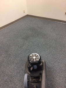 A professional carpet cleaning machine in action on a blue carpet by Ramirez Carpet Cleaning in Sacramento, CA