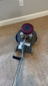A professional carpet cleaning machine in operation on a light brown carpet by Floor Medics in Huntsville, AL