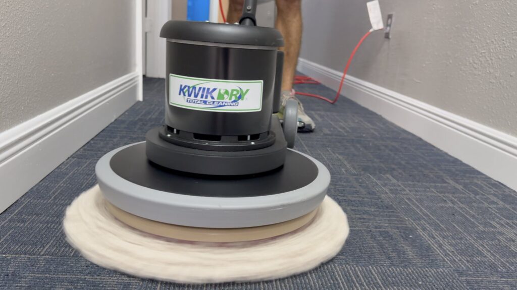 A professional carpet cleaning machine in action on a blue carpet by Rhode Island Kwik Dry in Providence, RI.