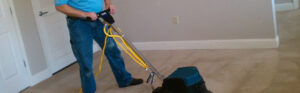 A professional operating a carpet cleaning machine on a light-colored carpet for Denver Cleanpro in Aurora, CO