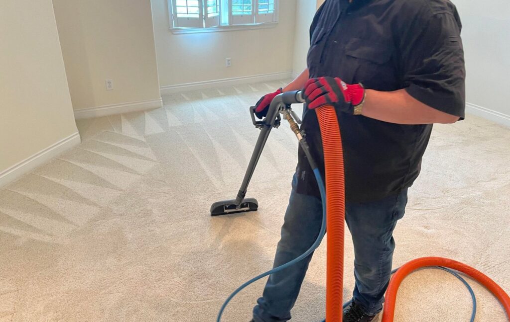 A professional from Alaska Dry Carpet cleaning a carpet, leaving visible clean lines in Anchorage, AK.