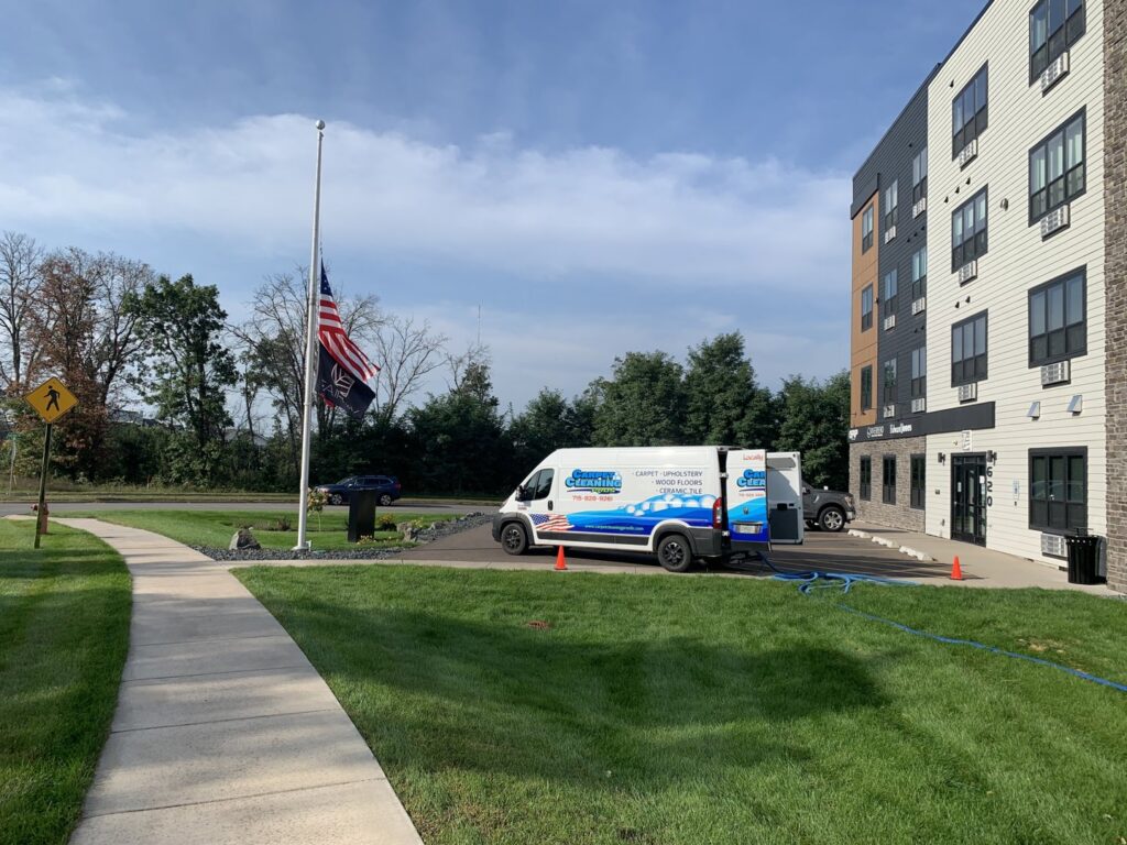 Carpet Cleaning Pros LLC service van parked outside a building with hoses, ready for a job in Eau Claire, WI.
