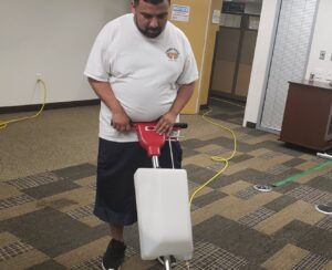 A professional performing carpet cleaning service with a machine at ARMS Commercial Cleaner in Los Angeles, CA