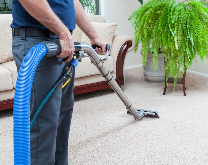 A professional performing carpet cleaning service with a machine on a light-colored carpet by Father and Son Companies in Gaithersburg, MD.