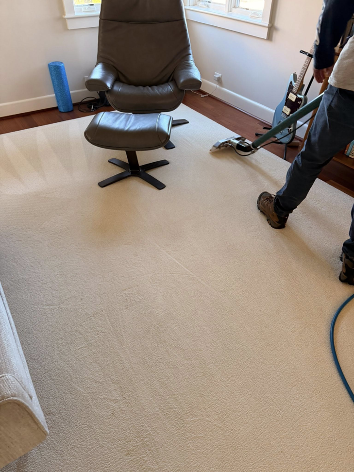 A professional performing carpet cleaning service with a machine on a light-colored carpet at First Response Custom Cleaning in Newport News, VA