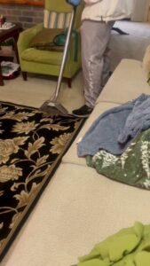 A professional performing residential carpet cleaning with a wand tool by Word of Mouth Cleaning Services in Houston, TX.