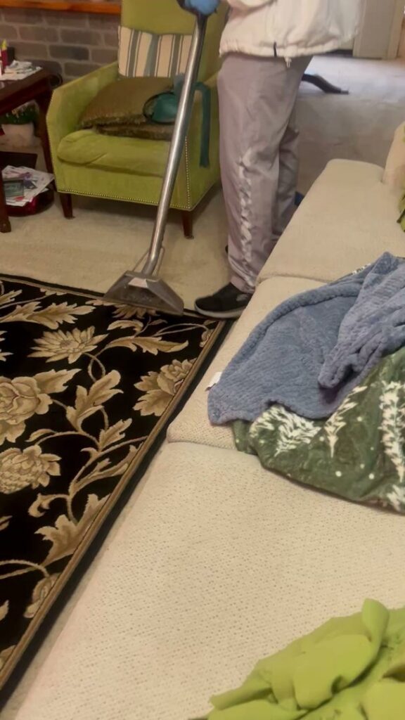 A professional performing residential carpet cleaning with a wand tool by Word of Mouth Cleaning Services in Houston, TX.