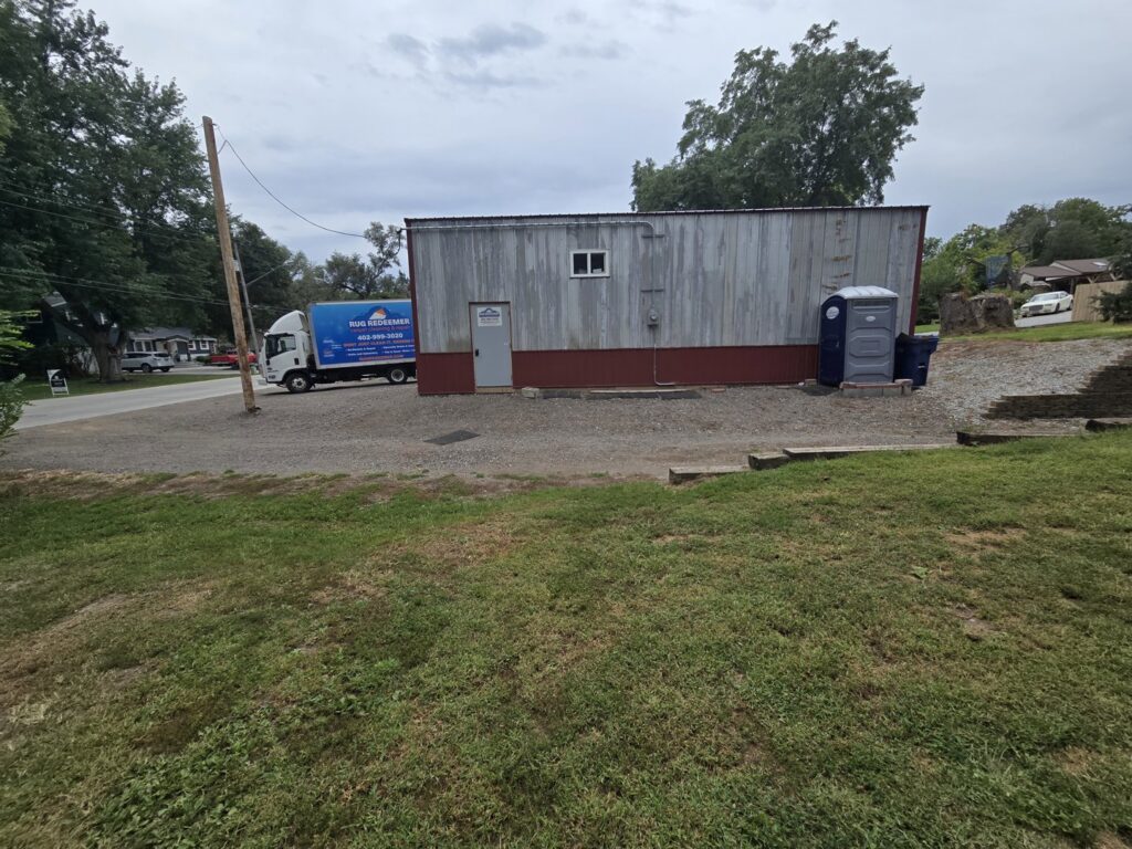 A Rug Redeemer carpet cleaning service truck parked outside a commercial building for Inspection Ready LLC in Bellevue, NE.