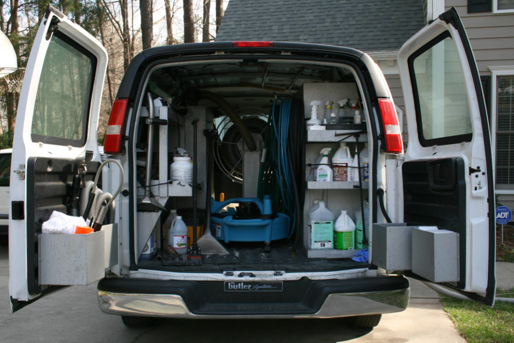 A service van with its doors open, revealing carpet cleaning equipment and supplies for Philadelphia Carpet Cleaning Co in Lansdowne, PA.
