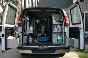 A service van with its doors open, revealing carpet cleaning equipment and supplies for Philadelphia Carpet Cleaning Co in Lansdowne, PA.