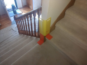 A carpet cleaning setup on stairs with protective drop cloths at Premium Carpet Care in Lincoln, NE.