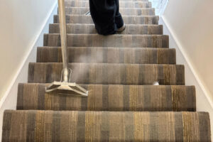 A carpet cleaning wand with visible steam cleaning carpeted stairs by Get Steamed Carpet Cleaning, Inc. in North Charleston, SC.